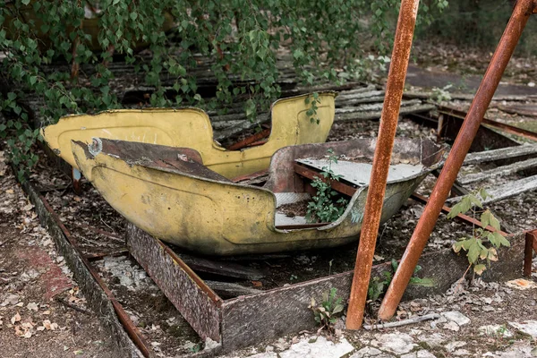 PRIPYAT, UCRÂNIA - AGOSTO 15, 2019: folhas verdes perto de construções metálicas abandonadas no parque de diversões — Fotografia de Stock