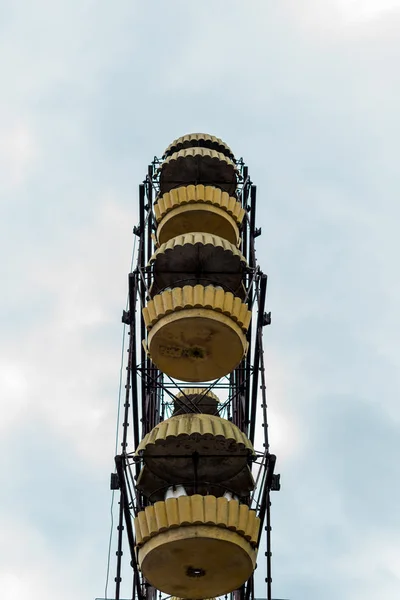 PRIPYAT, UCRAINA - 15 AGOSTO 2019: vista a basso angolo della ruota panoramica gialla contro il cielo blu con nuvole — Foto stock