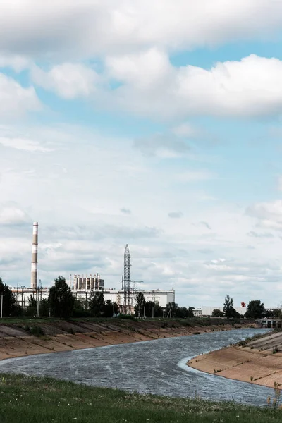 Pripjat, ukraine - 15. August 2019: stillgelegtes Atomkraftwerk Tschernobyl in der Nähe von Bäumen und Fluss — Stockfoto