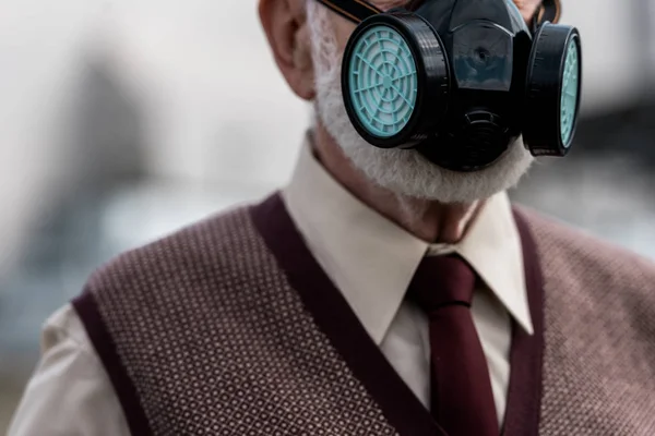 Cropped view of senior man in protective mask in chernobyl — Stock Photo