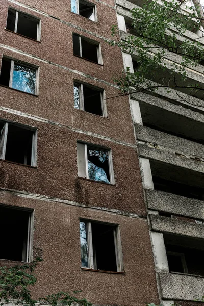 Verlassenes braunes Gebäude neben grünen Bäumen mit Blättern in Tschernobyl — Stockfoto