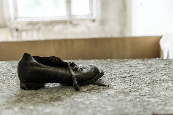 Selektiver Fokus des schmutzigen Schuhs auf flockiger Oberfläche — Stockfoto