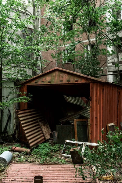 Garagem metálica perto de árvores verdes e construção — Fotografia de Stock