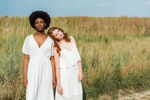 Young and attractive multicultural women standing in field — Stock Photo