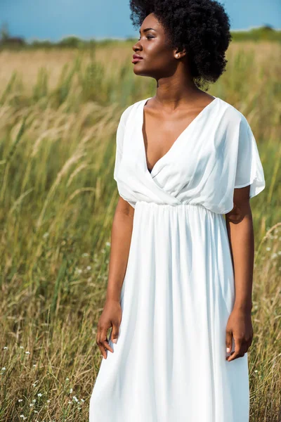 Attraktive afrikanisch-amerikanische Frau in weißem Kleid im Feld — Stockfoto