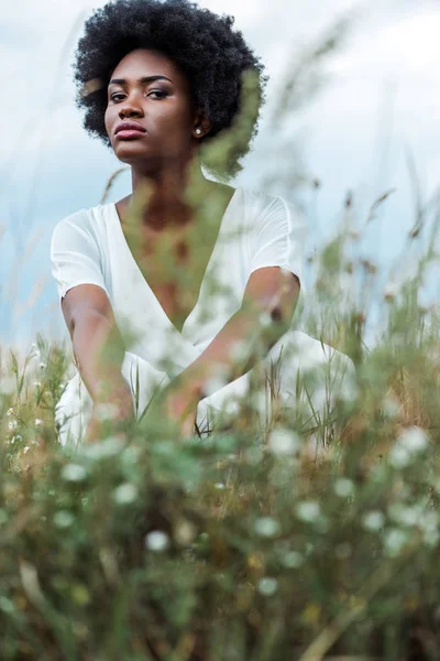 Selective focus of pretty african american woman in green field — Stock Photo