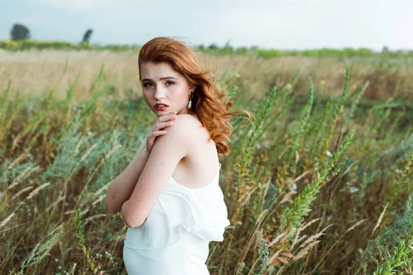 Красива руда жінка в білій сукні дивиться на камеру — стокове фото