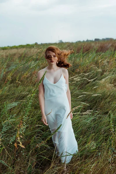 Jolie jeune femme aux cheveux roux debout en robe — Photo de stock