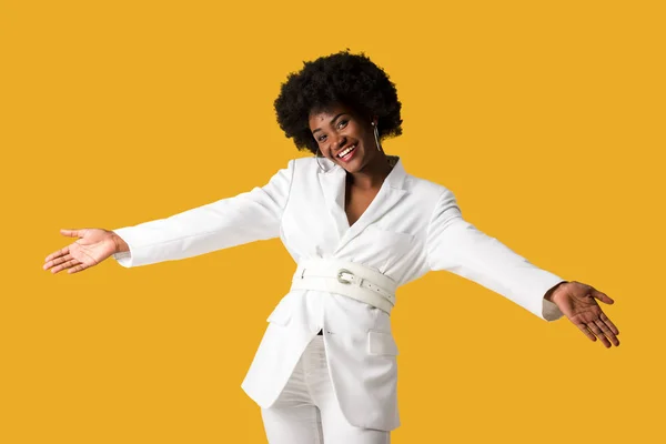 Mujer afroamericana feliz con las manos extendidas aisladas en naranja - foto de stock