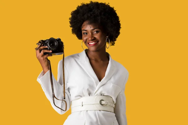 Feliz africano americano mujer celebración digitla cámara aislado en naranja - foto de stock