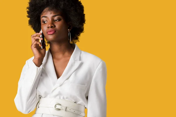 Привлекательная африканская американка разговаривающая на смартфоне изолированная на апельсине — стоковое фото
