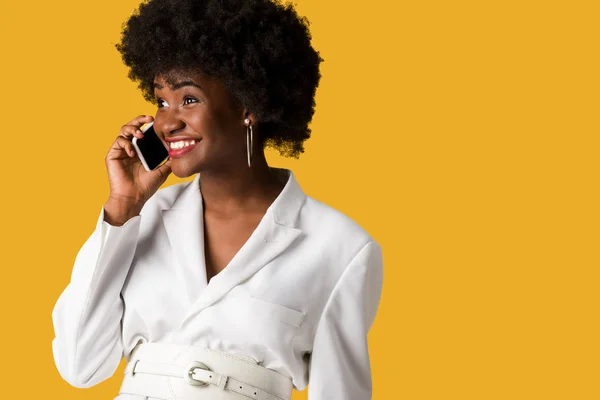 Mulher americana africana alegre e encaracolado falando no smartphone isolado em laranja — Fotografia de Stock