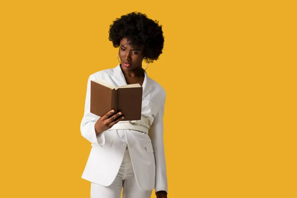 Surpris femme afro-américaine lecture livre isolé sur orange — Photo de stock
