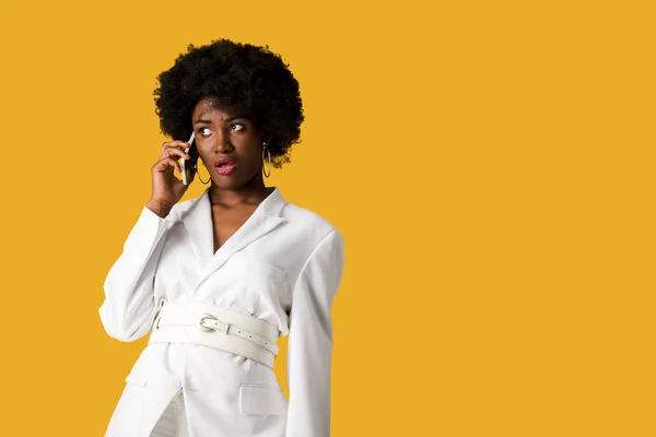 Chocado encaracolado afro-americano mulher falando no smartphone isolado em laranja — Fotografia de Stock