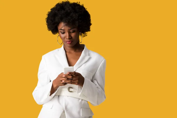 Belle frisée afro-américaine femme en utilisant smartphone isolé sur orange — Photo de stock