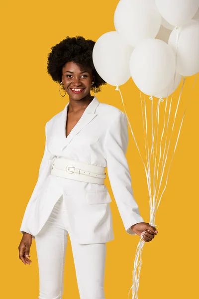 Happy african american woman holding balloons isolated on orange — Stock Photo