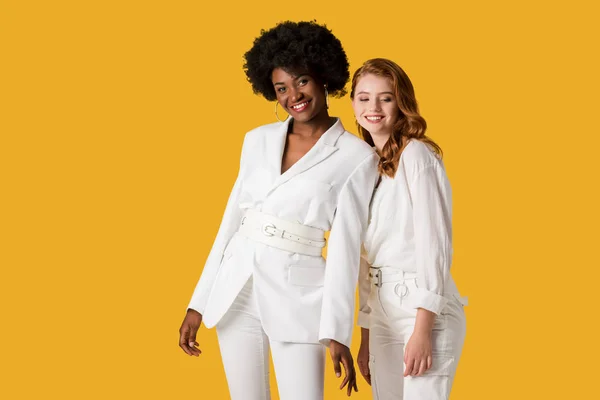 Happy multicultural girls standing isolated on orange — Stock Photo