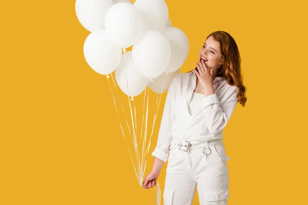 Alegre pelirroja chica celebración globos aislado en naranja - foto de stock