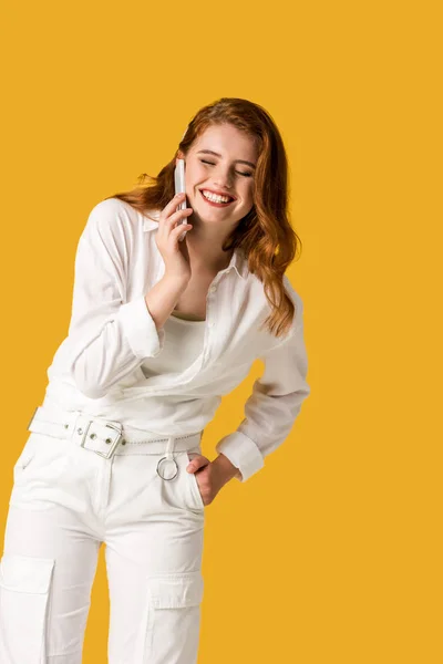 Happy redhead woman talking on smartphone isolated on orange — Stock Photo