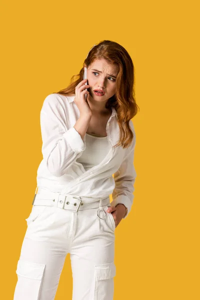 Femme rousse choquée parlant sur smartphone isolé sur orange — Photo de stock