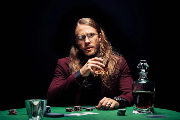 Selective focus of man in eye glasses near playing cards isolated on black — Stock Photo