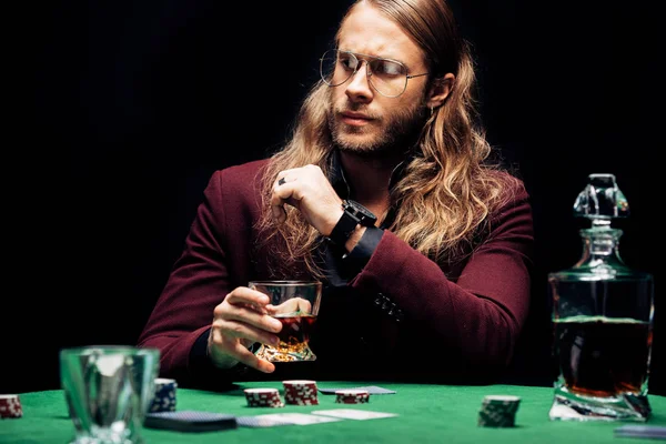 Foco seletivo do homem barbudo em óculos perto de jogar cartas isoladas em preto — Fotografia de Stock