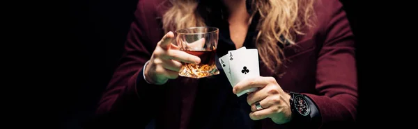 KYIV, UCRAINA - 20 AGOSTO 2019: colpo panoramico di uomo con carte da gioco e whisky isolato su nero — Foto stock