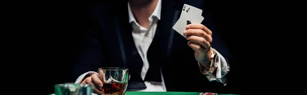 KYIV, UKRAINE - AUGUST 20, 2019: panoramic shot of man holding playing cards isolated on black — Stock Photo