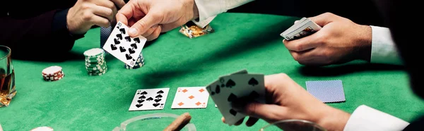KYIV, UCRANIA - 20 de agosto de 2019: plano panorámico de hombres jugando póquer cerca de la mesa de póquer - foto de stock