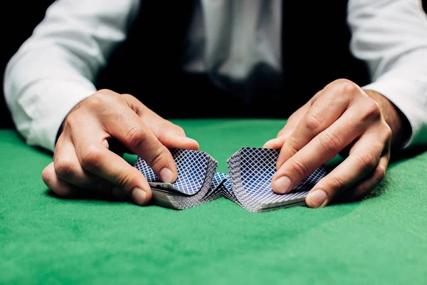 KYIV, UCRANIA - 20 de agosto de 2019: vista recortada del crupier sosteniendo cartas cerca de la mesa de póquer - foto de stock