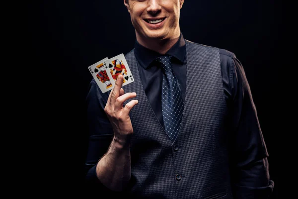 QUIIV, UCRÂNIA - 20 DE AGOSTO DE 2019: visão recortada do homem feliz segurando cartas de baralho e sorrindo isolado no preto — Fotografia de Stock