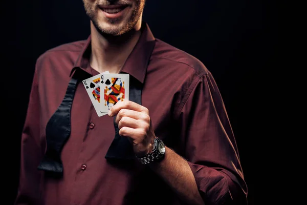 KYIV, UKRAINE - AUGUST 20, 2019: cropped view of happy bearded man holding playing cards isolated on black — Stock Photo