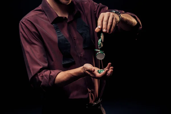 Vista recortada del hombre lanzando fichas de póquer aisladas en negro - foto de stock