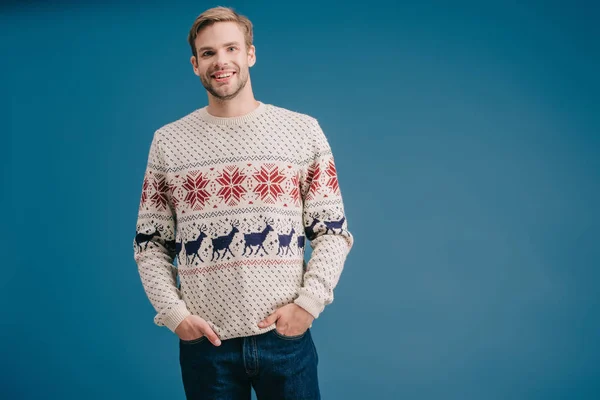 Bell'uomo sorridente in posa in maglione invernale isolato sul blu — Foto stock