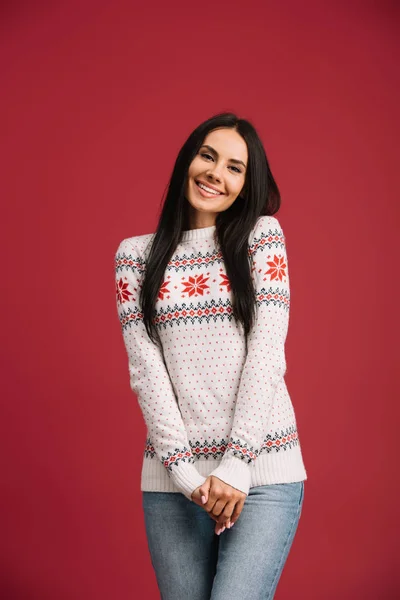 Mujer sonriente posando en suéter de invierno aislado en rojo - foto de stock