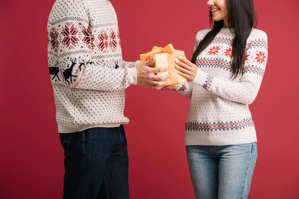 Vista ritagliata di coppia con Natale presente isolato su rosso — Foto stock