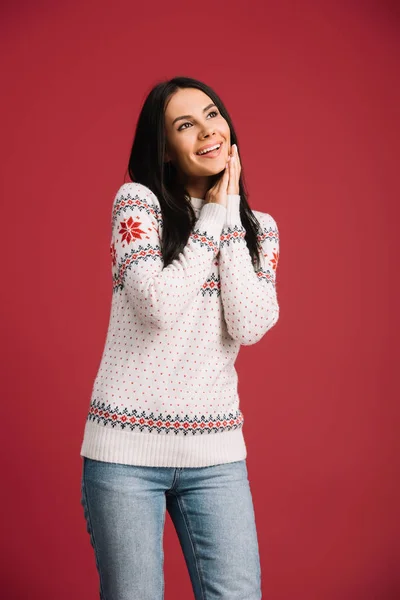 Menina feliz atraente posando em camisola de inverno isolado no vermelho — Fotografia de Stock