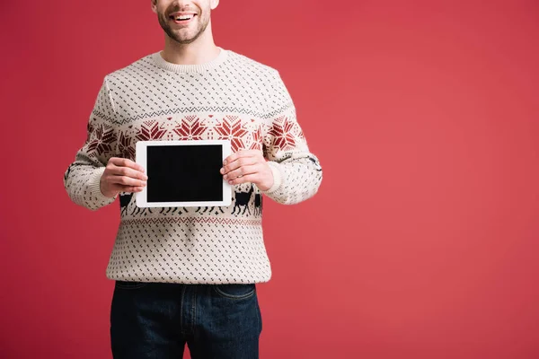 Vue recadrée de l'homme en pull d'hiver montrant tablette numérique avec écran blanc, isolé sur rouge — Photo de stock