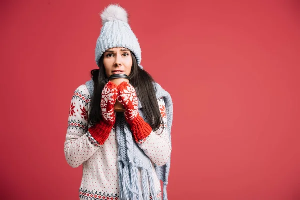 Mulher fria em chapéu de inverno, cachecol e mitenes segurando café para ir, isolado em vermelho — Fotografia de Stock