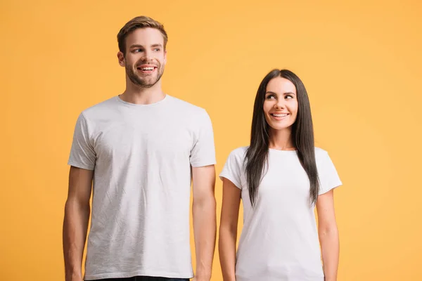 Belo casal alegre posando em camisetas brancas, isolado em amarelo — Fotografia de Stock