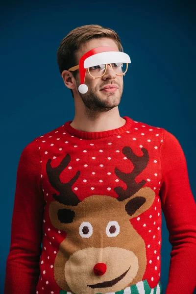 Mann posiert in Brille mit Weihnachtsmütze, isoliert auf blauem Grund — Stockfoto