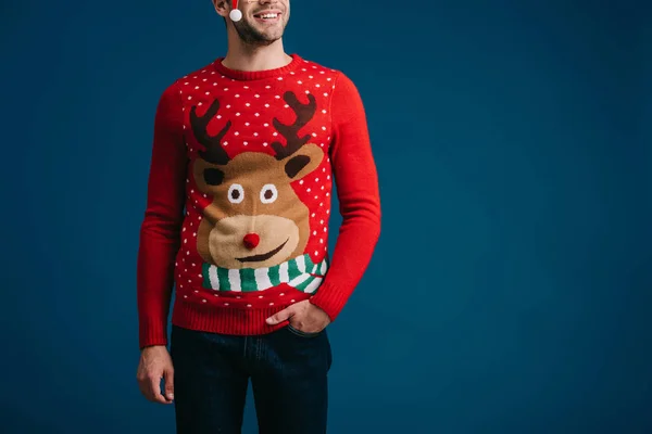 Homem bonito posando em camisola de Natal e óculos com chapéu de santa, isolado em azul — Fotografia de Stock