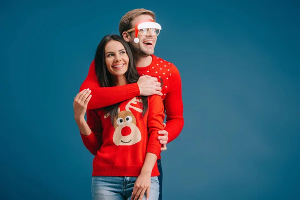 Feliz novio en gafas con santa sombrero novia mujer aislado en azul - foto de stock