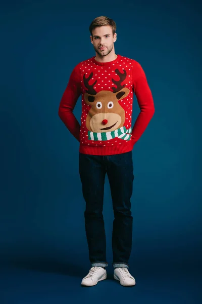 Hombre feliz posando en jersey de Navidad aislado en azul - foto de stock
