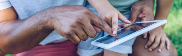 Vue recadrée du père et du fils afro-américain à l'aide d'une tablette numérique fils dans le parc, panoramique — Photo de stock