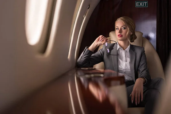 Atractiva mujer de negocios sentada en avión durante su viaje de negocios - foto de stock
