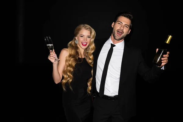Fröhliches Paar feiert mit Champagner auf Schwarz — Stockfoto