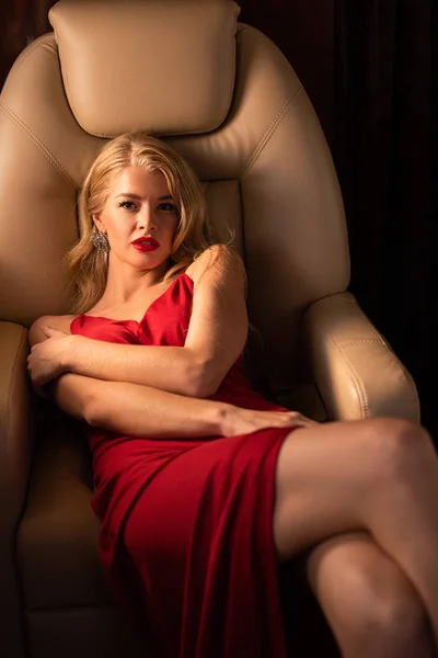 Sexy jeune femme en robe rouge assis dans l'avion — Photo de stock