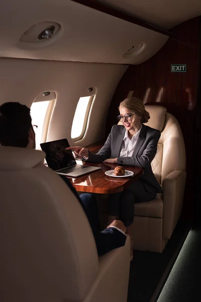 Профессиональные бизнес-менеджеры, работающие с ноутбуком в самолете — стоковое фото