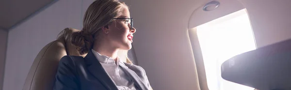 Приваблива бізнес-леді дивиться на вікно в літаку під час ділової поїздки — стокове фото